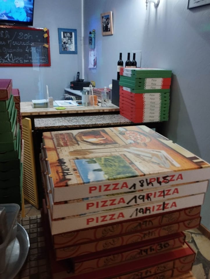 Comptoir Pizzas Popeye avec piles de boîtes et pizzas en attente de retrait