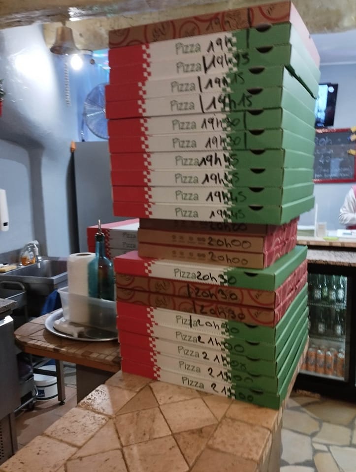Pile de cartons Pizzas Popeye marqués des heures de retrait, prêts à être emportés